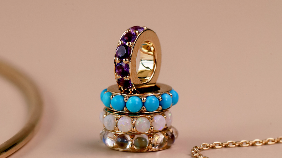 Flatlay of 4 rondelles featuring different colored gemstones stacked together against a beige neutral background