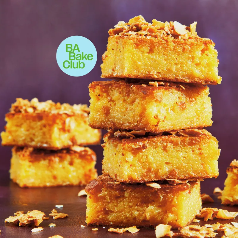 Several stacks of sweet corn-coconut crunch butter mochi cake squares.