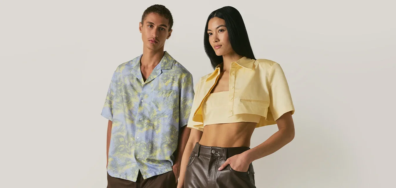Giovane uomo e donna in piedi fianco a fianco, indossando abiti estivi casual e alla moda su uno sfondo beige semplice.