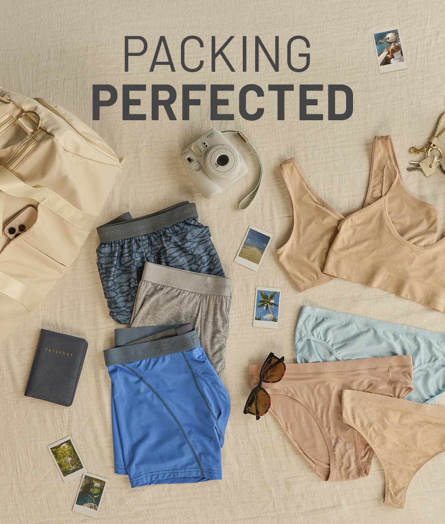 Packing Perfected. Overhead flat lay on beige linen of a duffel bag, instant camera, polaroid photos, sunglasses, keys, and ExOfficio travel underwear in blue, grey, tan and pale blue.