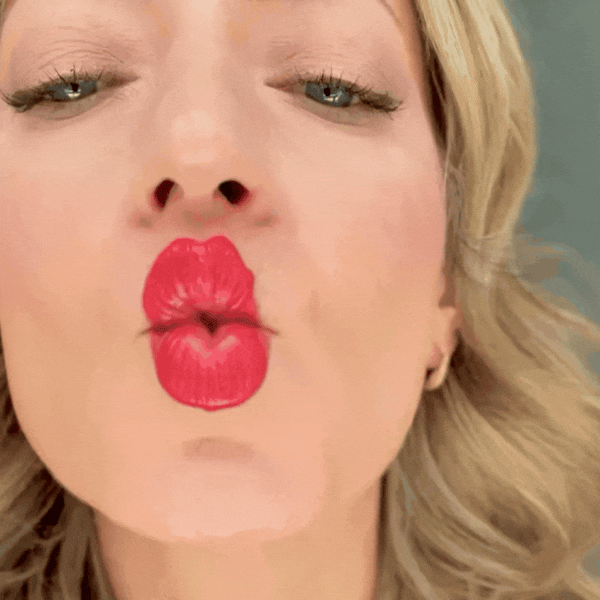A GIF of a woman blowing a kiss.