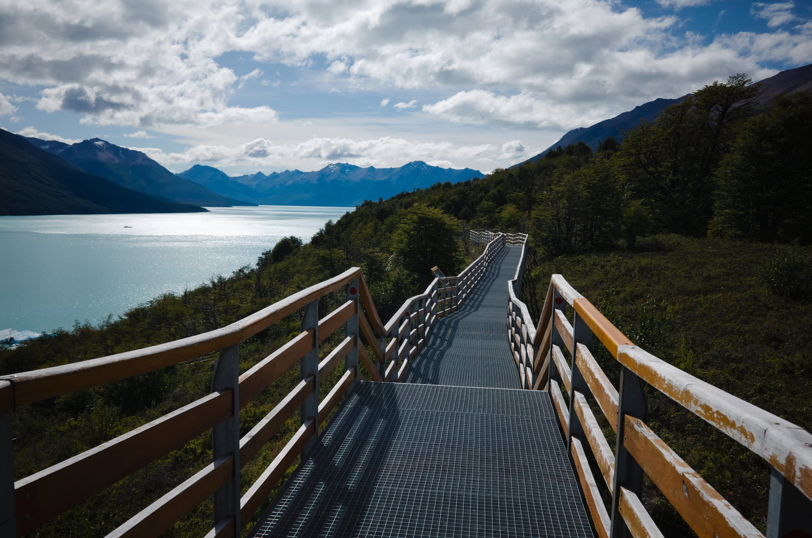 Pasarela metálica curva del Parque Nacional Los Glaciares hacia un lago turquesa, cerca de El Calafate