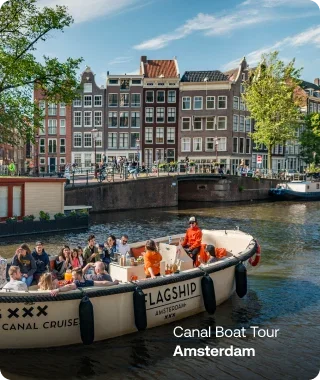 Group enjoying a canal boat tour past Amsterdam's historic canal houses.