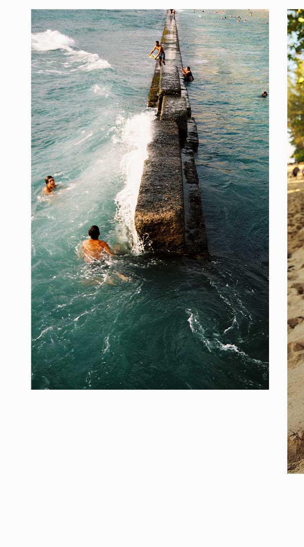 Men swimming near jetty in the ocean