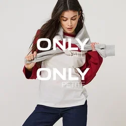 Vrouw draagt een wit-rode longsleeve, donkerblauwe opgerolde jeans, zwarte schoenen, houdt een grijze trui over haar schouders.