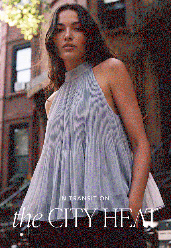 In Transition: The City Heat. Woman in a pleated halter top on a city street.