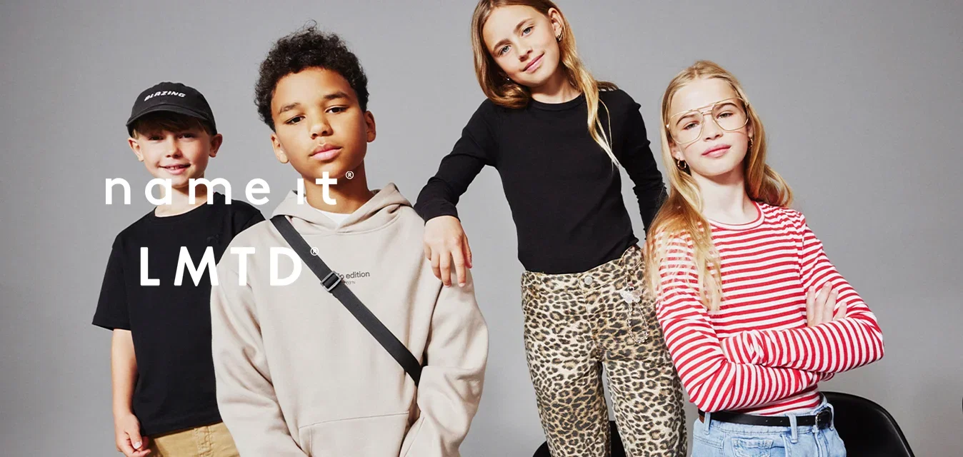Vier kinderen poseren zelfverzekerd tegen een grijze achtergrond, gekleed in casual moderne kleding met verschillende stijlen en kleuren.