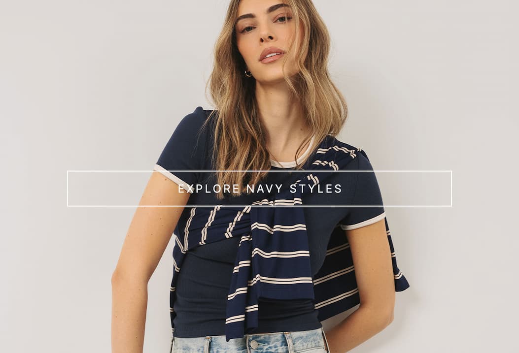 Model wearing navy ribbed essentials with a striped knit layered over the shoulders and CTA overlay.