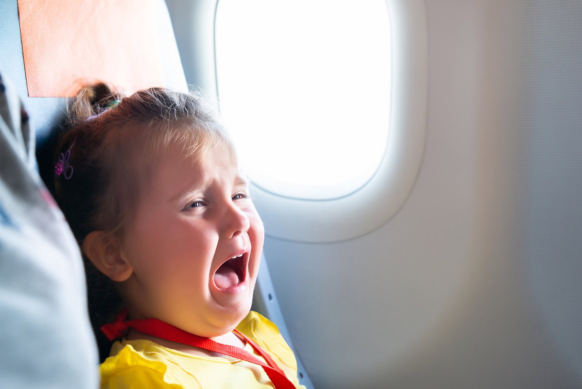 Une petite fille crie dans un avion