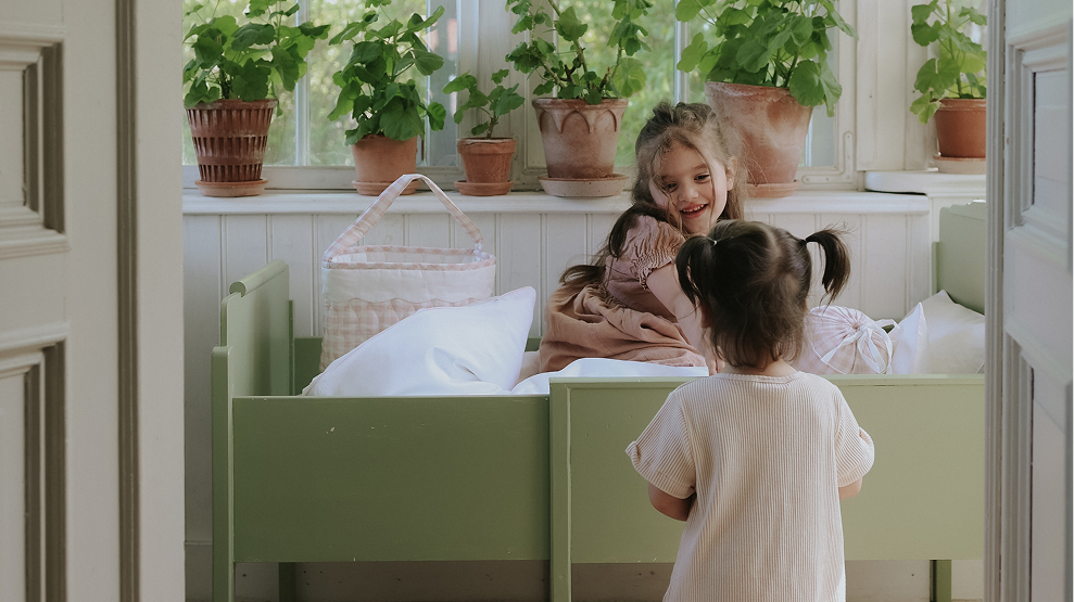 older girl in bed with younger girl by side