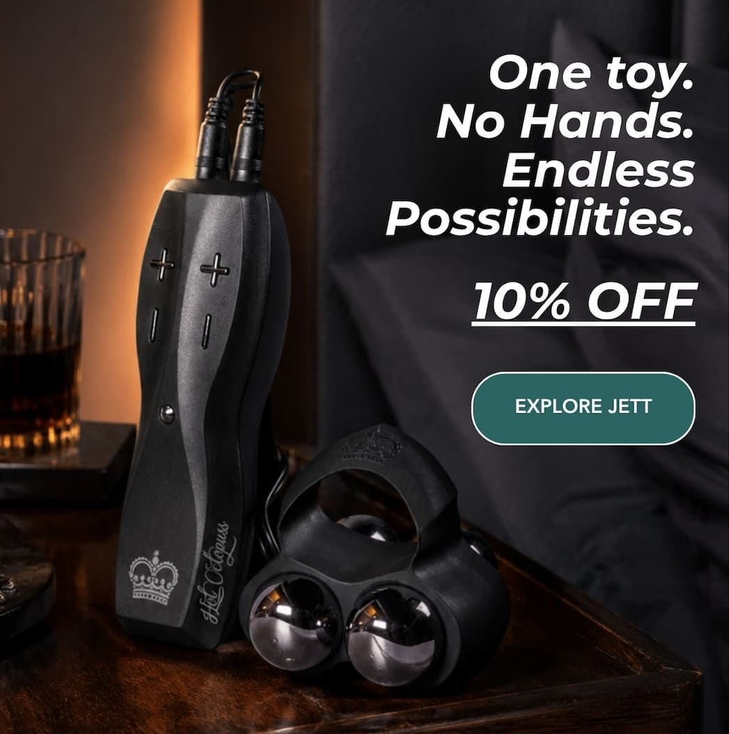 JETT hands-free male masturbator with remote control, silicone sleeve and vibrating bullets on a bedside table.