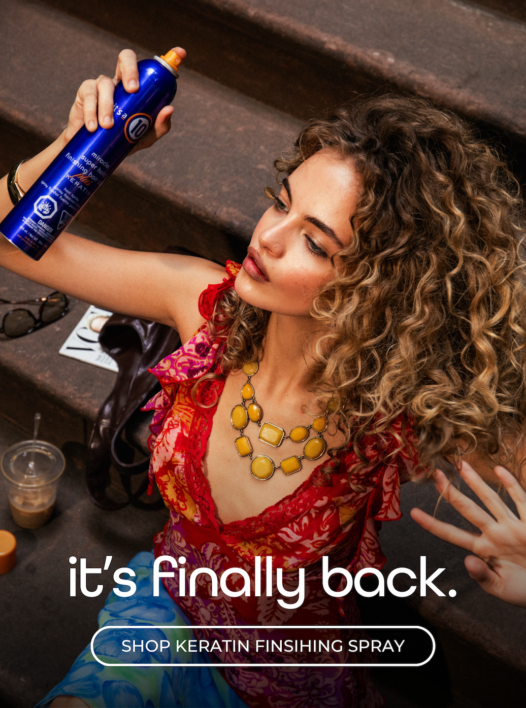 Girl using It's a 10 keratin finishing spray on stairs