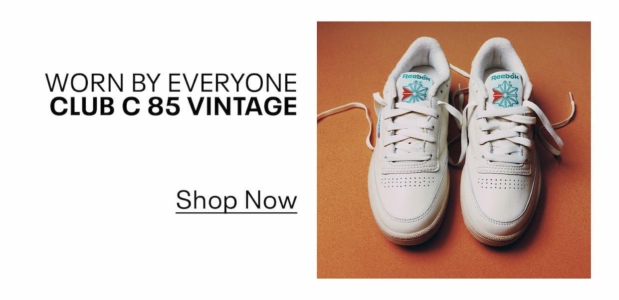 Pair of white Club C 85 Vintage sneakers displayed on a brown background. Text reads: “WORN BY EVERYONE. CLUB C 85 VINTAGE. Shop Now.”