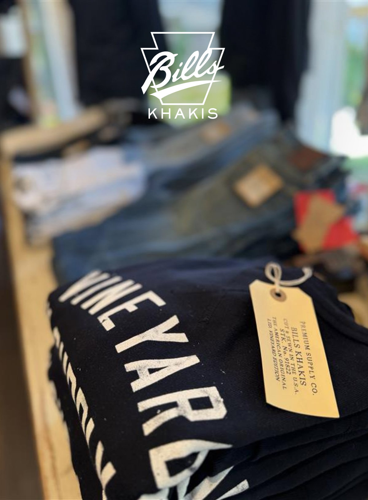 A shot of shelf merchandising in the Edgartown Bills Khkis location wit a shirt with the words Wineyard on it