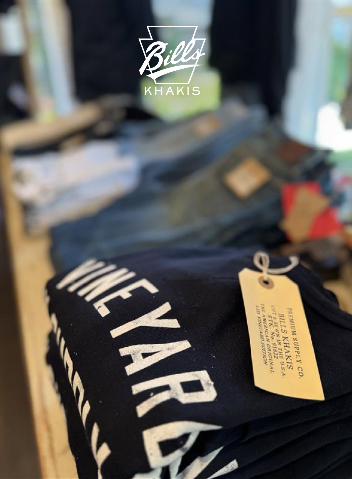 A shot of shelf merchandising in the Edgartown Bills Khkis location wit a shirt with the words Wineyard on it