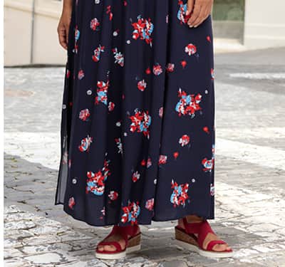 Ein Model trägt ein marine-gemustertes Maxikleid mit Allover-Blumendruck