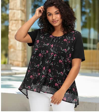 Ein Model trägt ein schwarz-gemusterts Blusenshirt in Lagenoptik, mit Rundhalsausschnitt und kurze Ärmeln