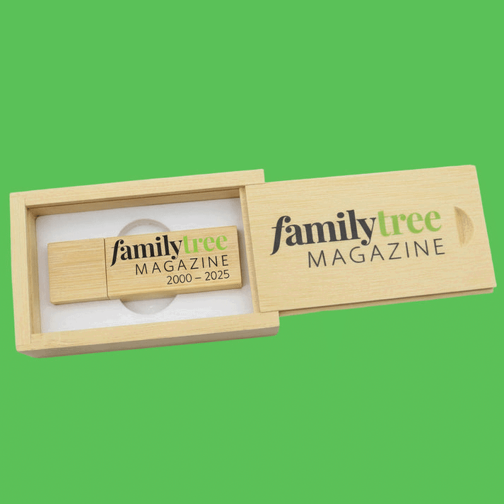 A wooden box with a sliding lid labeled "Family Tree Magazine" contains a USB drive marked "family tree 2000 – 2025" against a green background.