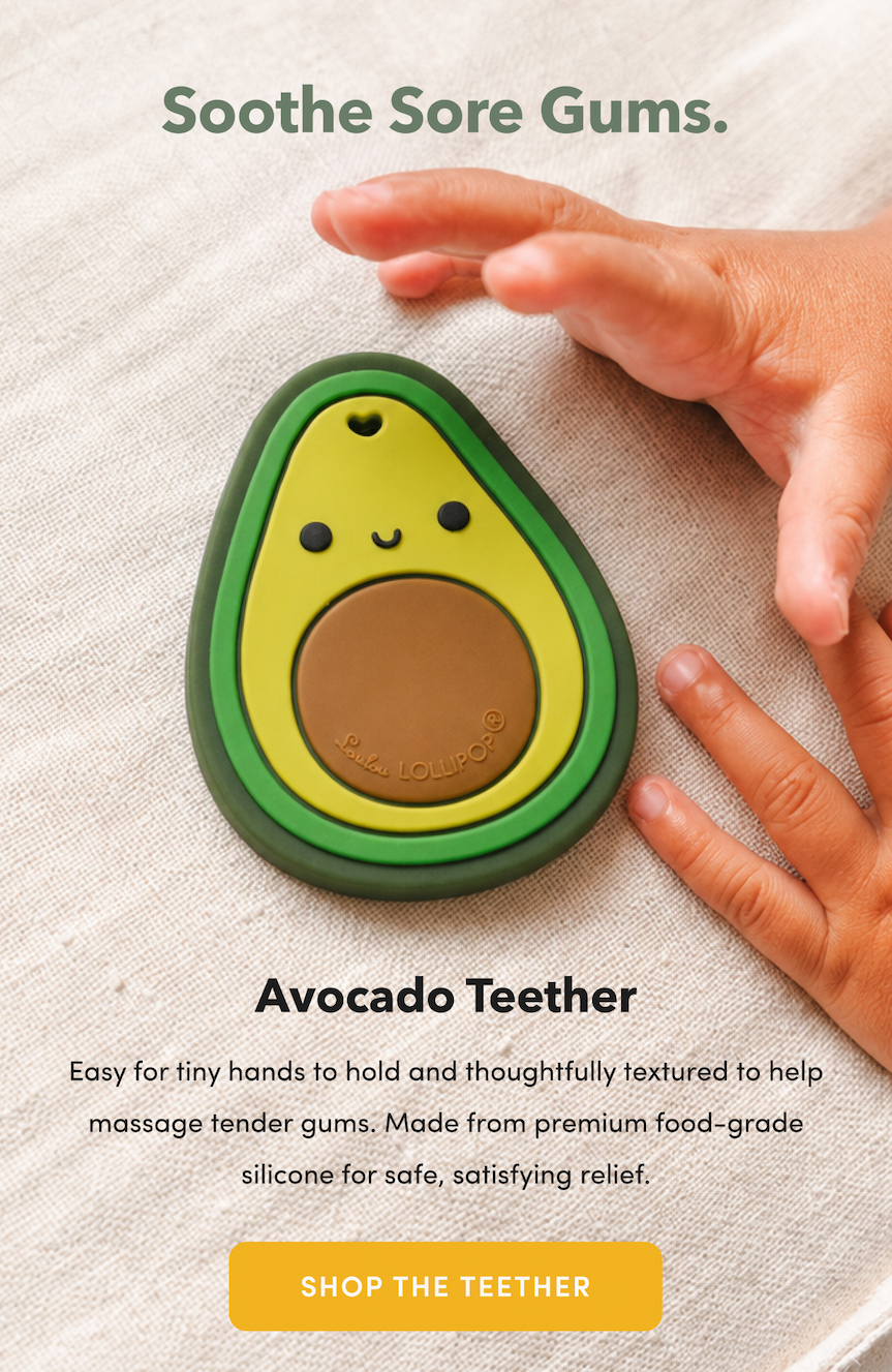 close up of an avocado shaped silicone baby teether and toddler hands grabbing it