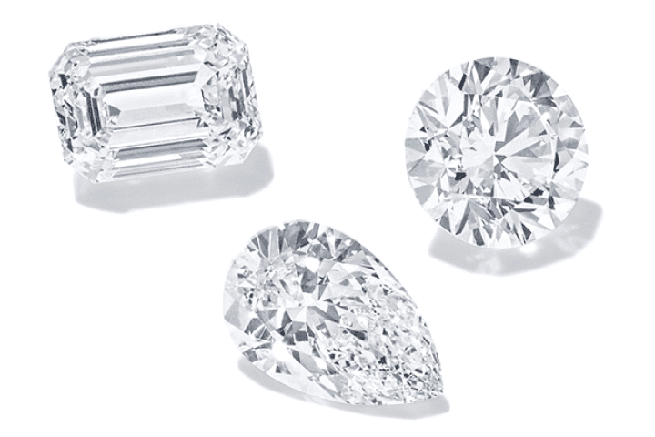 Emerald, round and pear cut diamonds displayed on a light background.