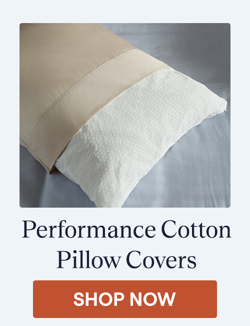 The Performance Cotton Pillow Cover on a pillow with a pillowcase on top of it sitting on a bed