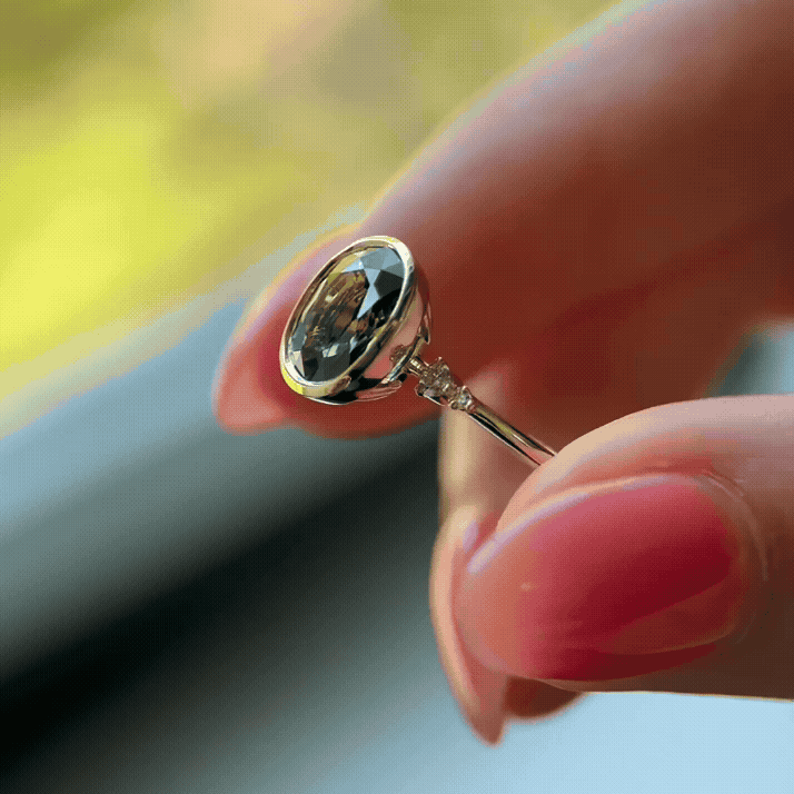 The Bezel Pictorial Ring, 2.57ct. Bicolor Yellow and Green Sapphire shown being held up by a model