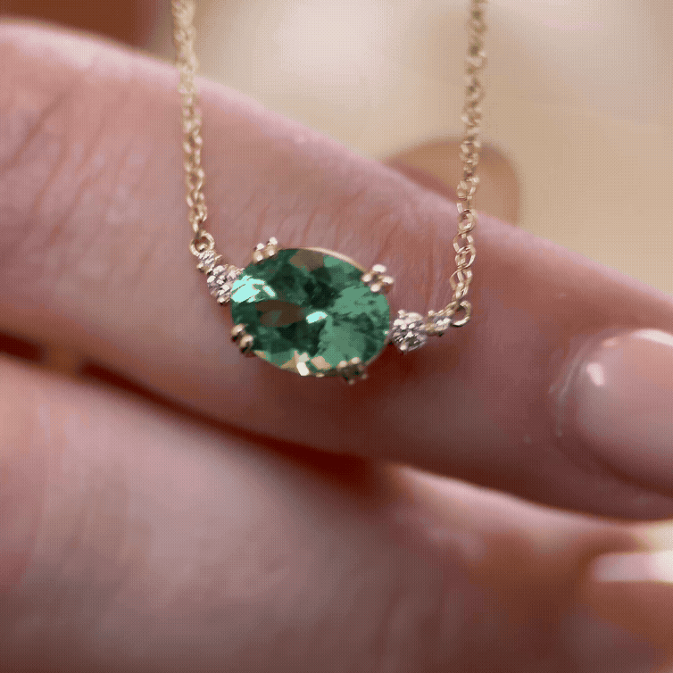 The Pictorial Necklace, 1.86ct. Green Afghanistan Tourmaline shown being held up against a model's hand