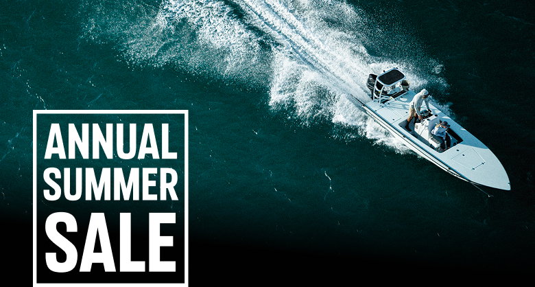 Aerial shot of a boat in the ocean with text: ANNUAL SUMMER SALE