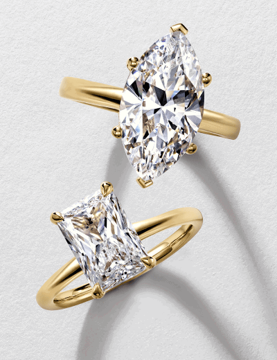 Yellow gold marquise-cut and emerald-cut diamond solitaire rings.