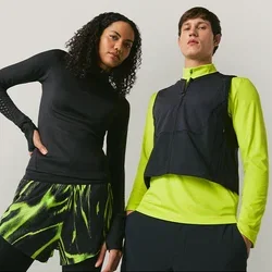 Twee modellen staan tegen een effen achtergrond, de een draagt zwarte en neon groene sportkleding, de ander een zwarte top en een neon groene jas met een vest.
