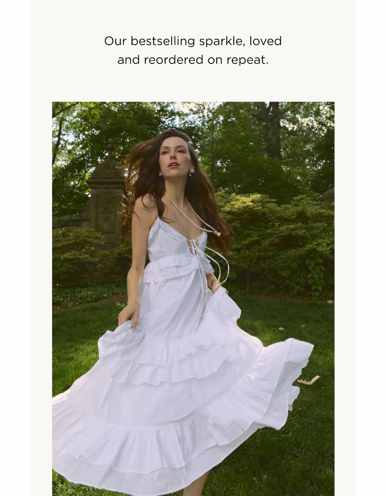 MODEL IN A WHITE SUNDRESS WEARING BOUJEE BEAD MOONSTONE NECKLACE, EVERLEIGH HAND CHAIN, EMILIA PEARL LINE BRACELET.