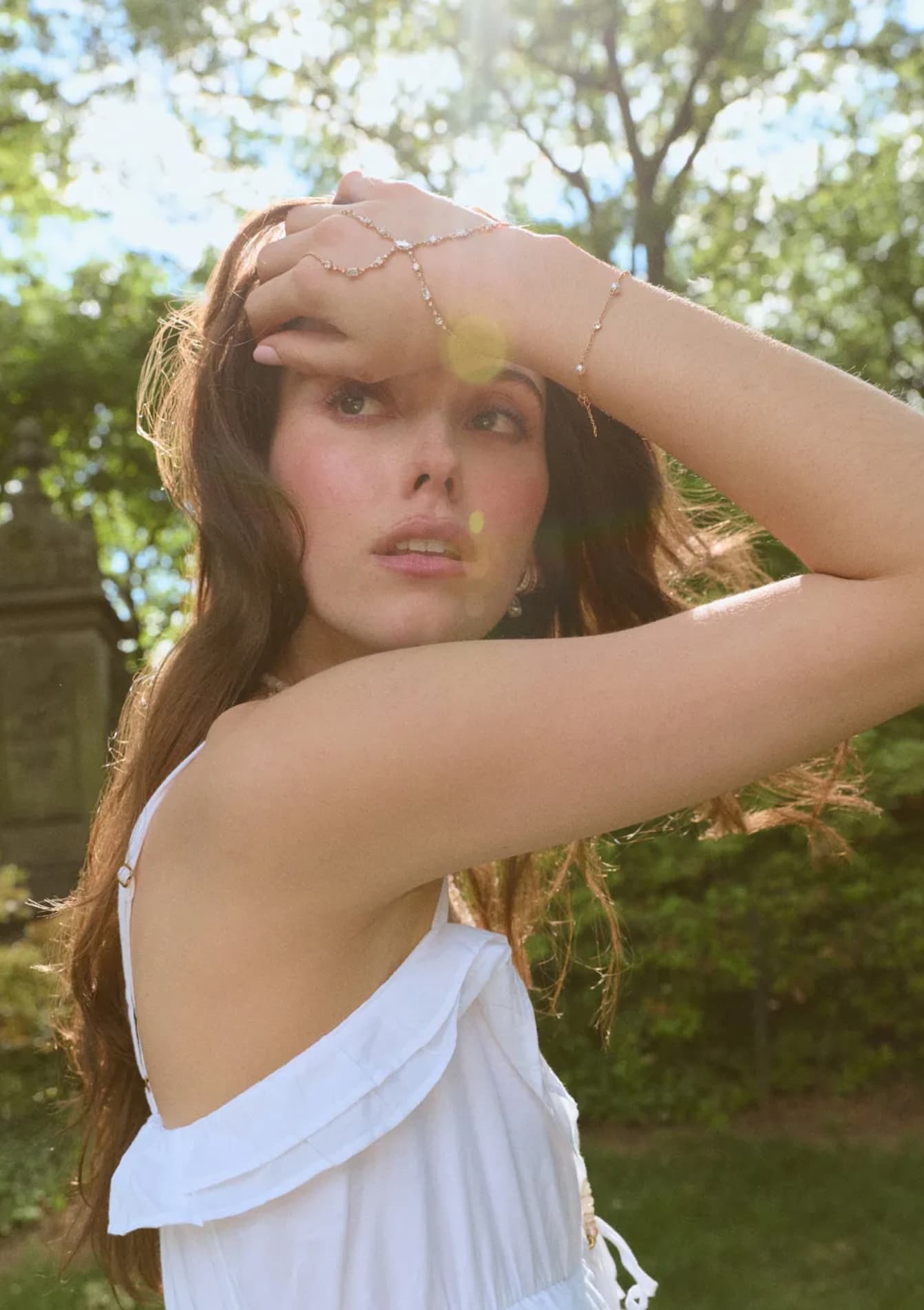 MODEL IN A WHITE SUNDRESS WEARING BOUJEE BEAD MOONSTONE NECKLACE, EVERLEIGH HAND CHAIN, EMILIA PEARL LINE BRACELET.