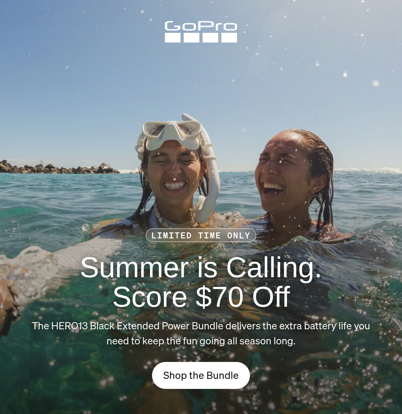 Two women laughing while taking a selfie in the ocean.