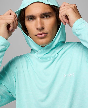 A man wearing a light blue sun hoodie.