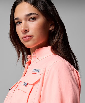 A woman wearing a light pink button-up shirt. 