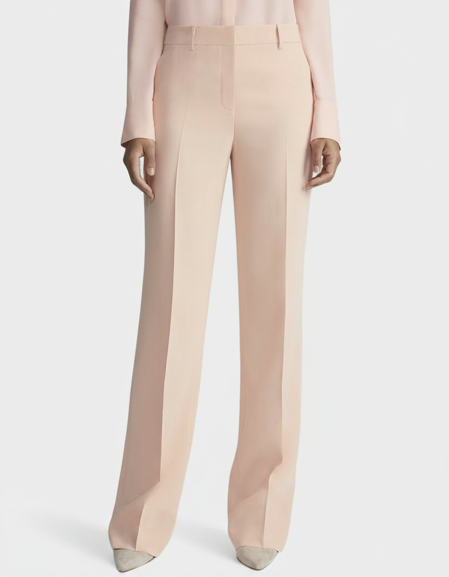 A person wears pale pink wide-leg trousers and a matching blouse.