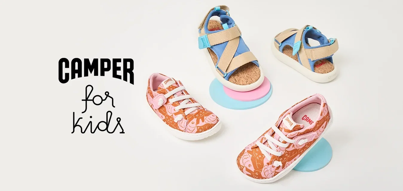 Twee paar kinderschoenen op ronde platforms: één oranje met roze patronen en witte veters, en beige sandalen met blauwe accenten.