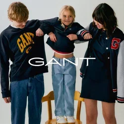 Twee tieners en een kind staan op een stoel. De tieners dragen donkere hoodies; één heeft een logo. Het kind draagt een cropped top en lichte jeans.