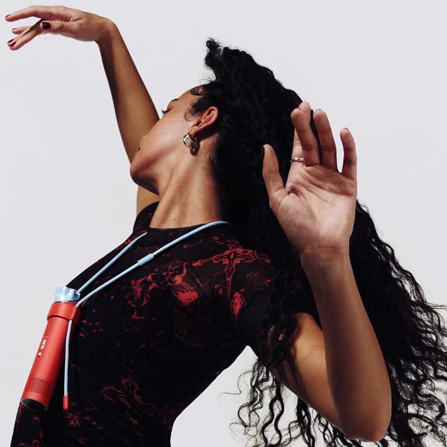 A dancer uses the Dyson HushJet Mini Cool fan in the Neck Dock to stay cool.