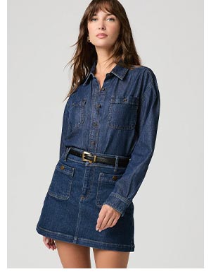 A woman wearing a blue denim shirt and skirt set.