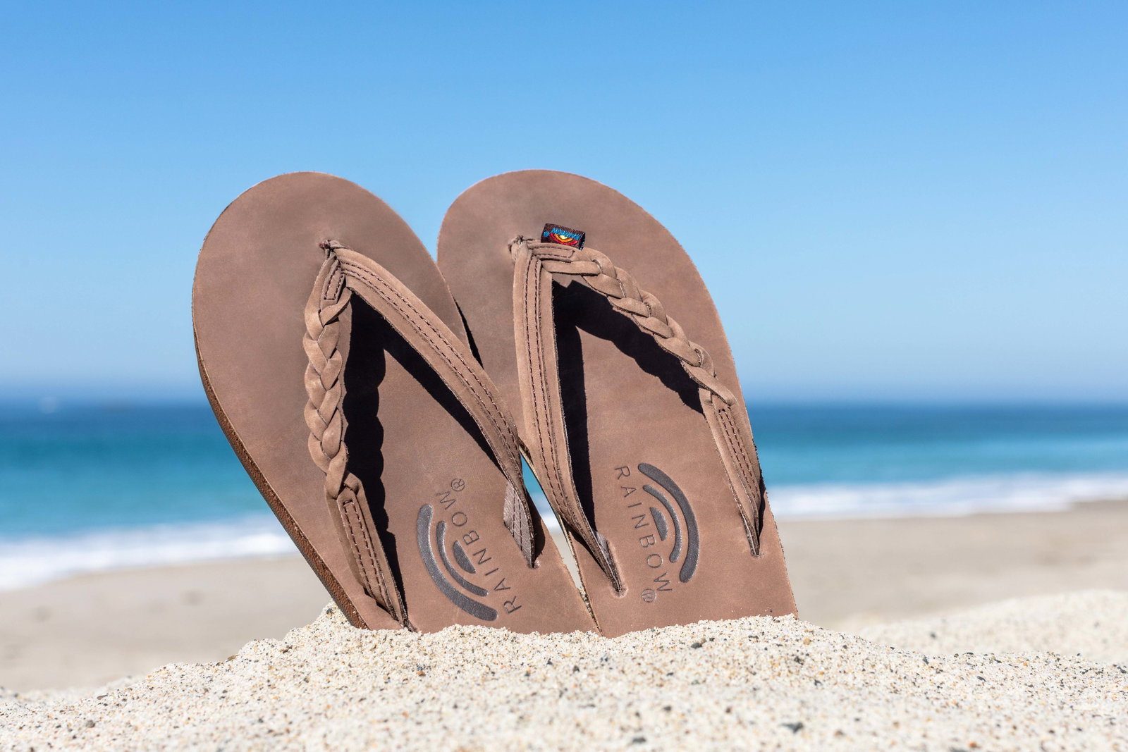 a pair of Expresso - Flirty Braidy sandals on the beach