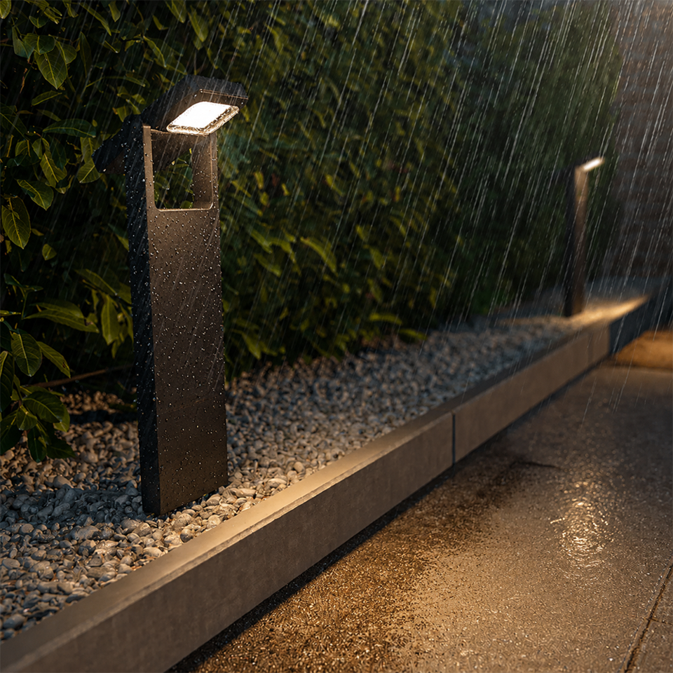 The Alton solar-powered LED path light illuminates a garden path during a rain shower. Thanks to its IP54 protection rating, the light is resistant to rain, moisture and dust, making it suitable for reliable and atmospheric outdoor lighting all year round.
