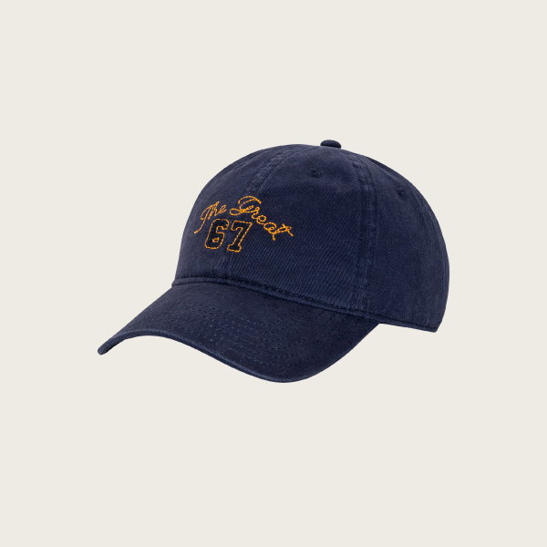 The Baseball Hat by THE GREAT. PF26 in navy features yellow "The Great 67" embroidery on the front.