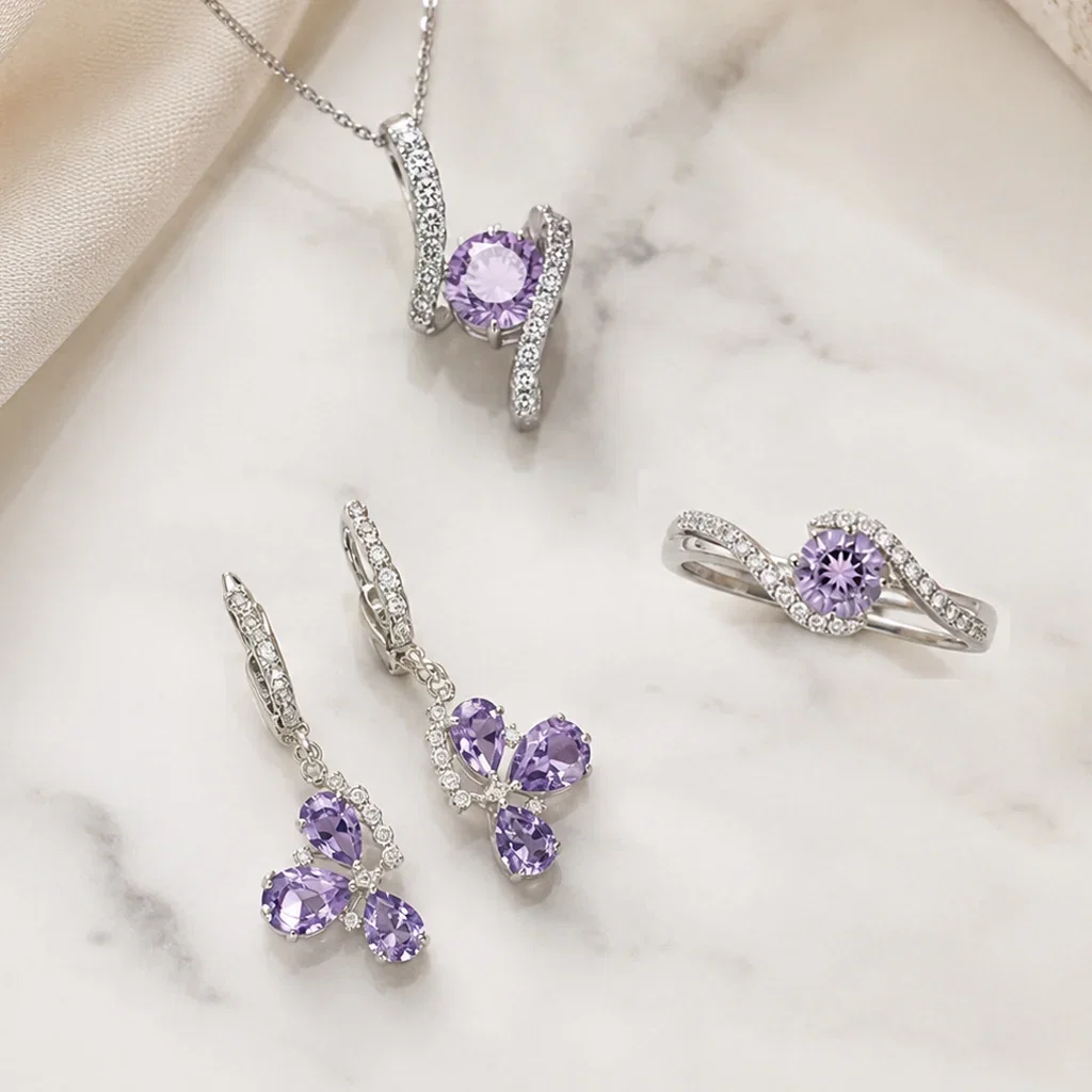 Silver amethyst jewelry set featuring a pendant, earrings, and ring on marble background with cream fabric.