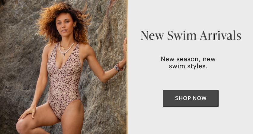 New Swim Arrivals  - Woman in Dahlia Top and Erin Bottom standing by boardwalk with ocean in background. 