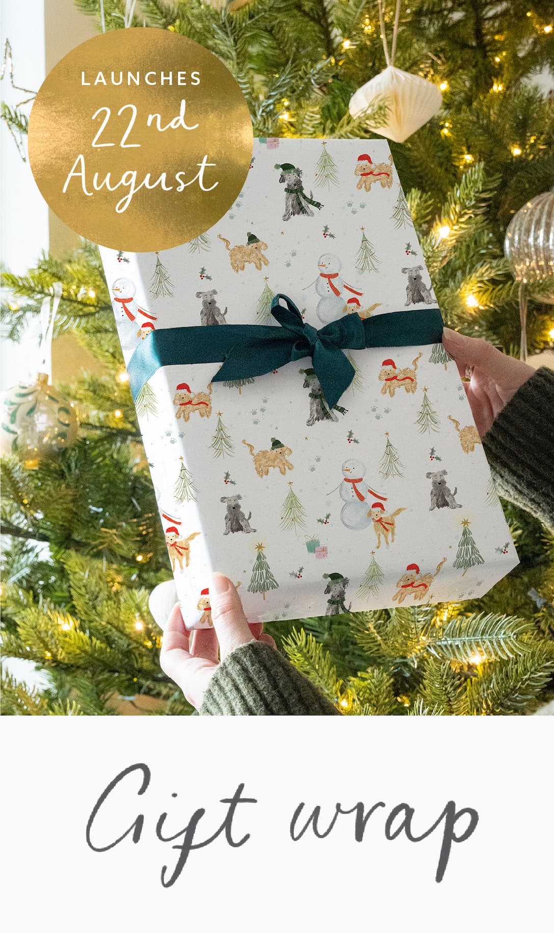 Christmas gift wrap launches 22nd August, featuring playful festive dogs and snowmen, finished with a deep green velvet ribbon.