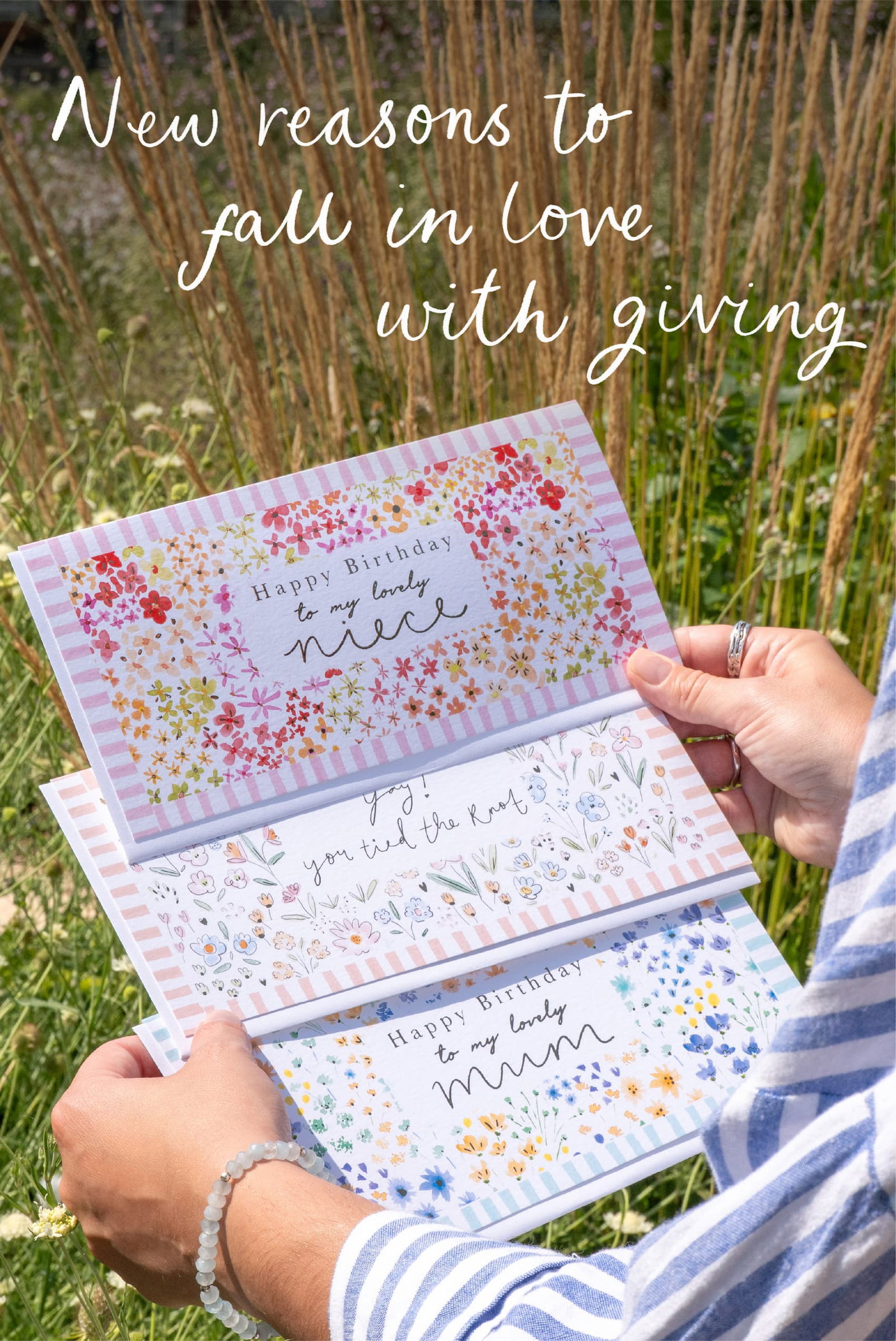 Colourful floral greeting cards in the summer sunshine, with the words: New reasons to fall in love with giving.