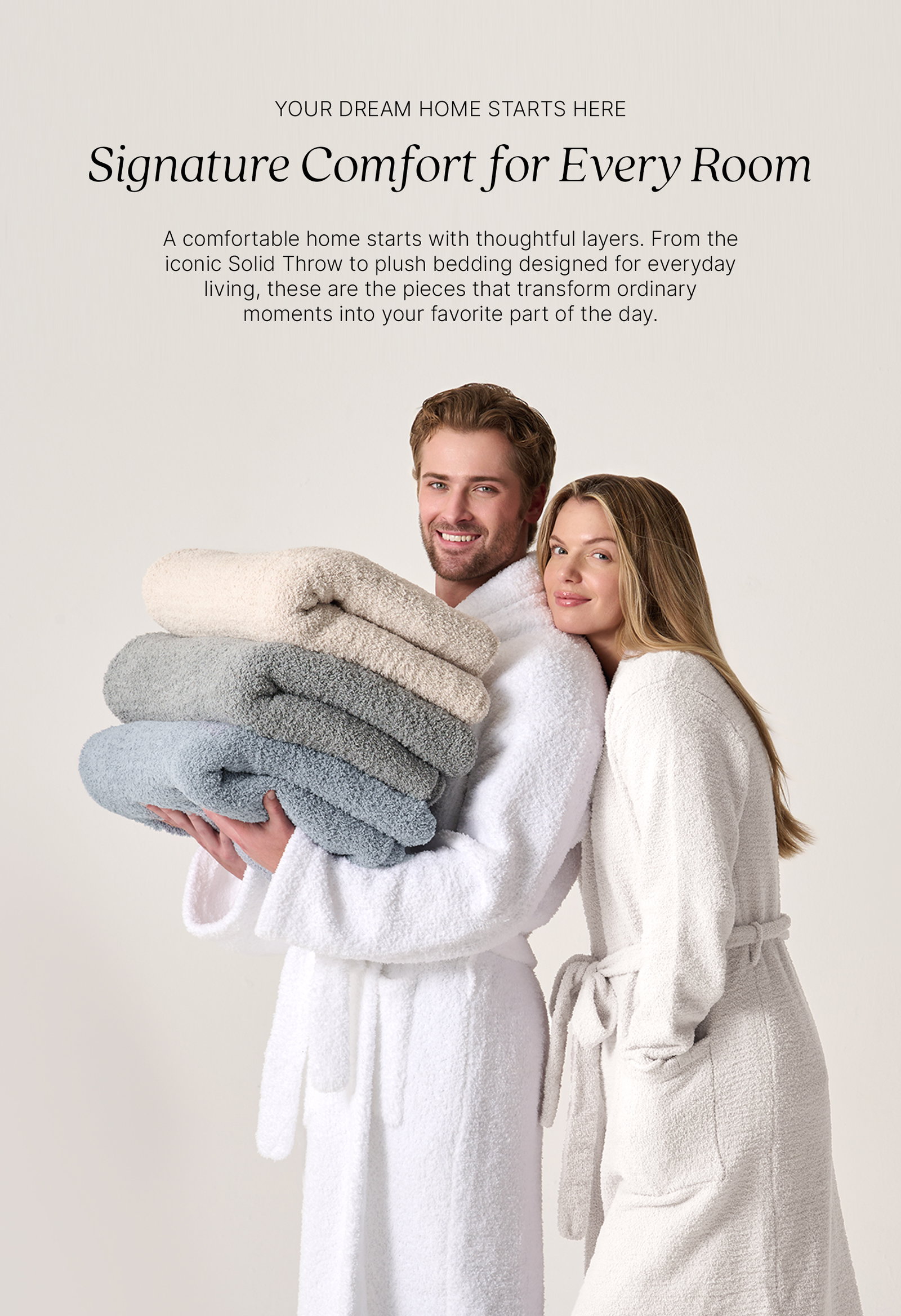 YOUR DREAM HOME STARTS HERE Signature Comfort for Every Room  A comfortable home starts with thoughtful layers. From the iconic Solid Throw to plush bedding designed for everyday living, these are the pieces that transform ordinary moments into your favorite part of the day.  Image of a couple wearing White Kashwére robes while holding a stack of Solid Throws in Bone, Mist, and Ice Blue.