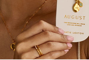 Our Newest Addition, the Birthstone Necklace, being held up by a model