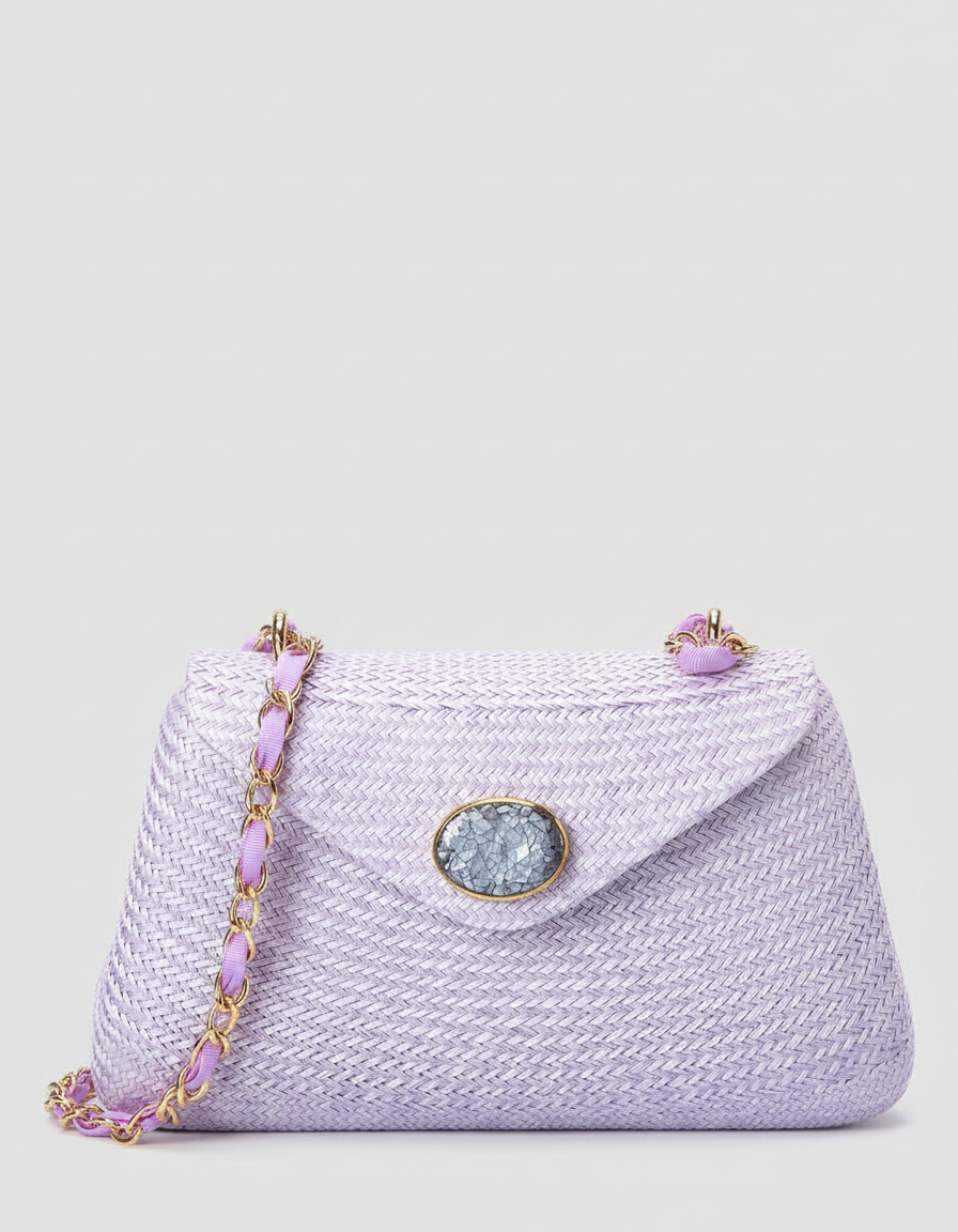 A light purple woven crossbody bag with a gold chain and a decorative oval clasp.